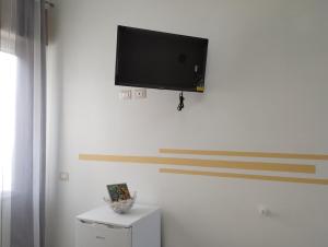 a flat screen tv hanging on a white wall at Monti d'aMare in Agerola