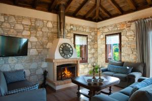a living room with a stone wall with a fireplace at 2 beautiful sea villas 17guests in Damouchari