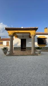 a large building with a door and pillars in front at Casa Rural El Escondite in Ronda