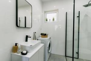 a bathroom with a sink and a washing machine at Domek pod Nowiną in Tylmanowa +31 photos