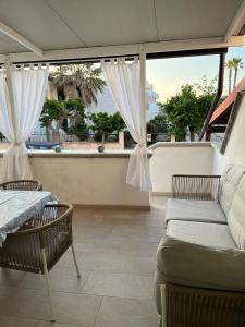 un patio con 2 sillas, un sofá y una ventana en villa TiCia a 100 metri dalla spiaggia con parcheggio privato, en Lido Marini