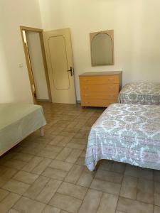 1 dormitorio con 2 camas, tocador y espejo en villa TiCia a 100 metri dalla spiaggia con parcheggio privato, en Lido Marini