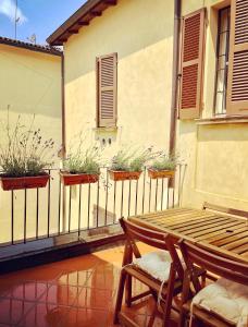 a balcony with a table and chairs and plants at Green House city center in Bologna