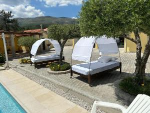 a couple of beds sitting next to a pool at Quinta da Menina Guest House in Vila Real