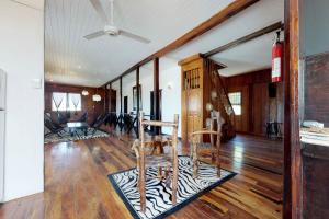 un soggiorno con pavimenti in legno e ventilatore a soffitto di The French Lady Guest House - Entire House a Caye Caulker
