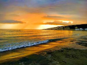 a sunset over a beach with the ocean at Apartments Art in Ulcinj +92 photos