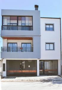 Un edificio de apartamentos blanco con garaje. en RIALTO dpto COCHERA Cubierta Asador individual, en Villa Mercedes