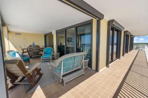 奧蘭治海灘的住宿－Summer House 901A by ALBVR - Gorgeous Beachfront Corner Condo with Incredible Views，门廊配有椅子和桌子