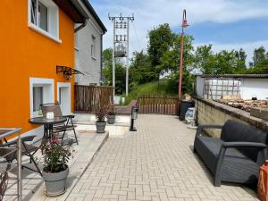 een patio met tafels en stoelen naast een gebouw bij Le Potiron in Scheidgen