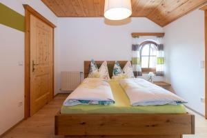 una camera con un grande letto con struttura in legno di Landhaus Widlroither a Mondsee