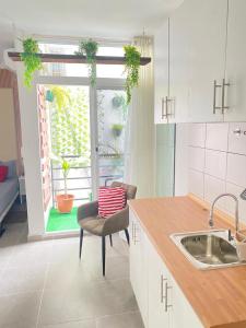 eine Küche mit einem Waschbecken, einem Stuhl und einem Fenster in der Unterkunft Quarto Nº8 LUMA - Central Praia in Praia