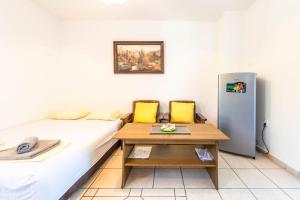a room with a bed and a table and a refrigerator at Ogi Seaside Gajac in Novalja