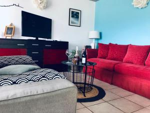 ein Wohnzimmer mit einem roten Sofa und einem TV in der Unterkunft Chez Mario 