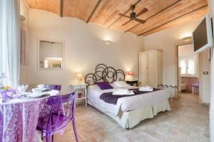 a bedroom with a bed and a table and a tv at Viterbo Antica - centro storico in Viterbo