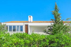 a white house with a tree in front of it at Ogi Seaside Gajac in Novalja