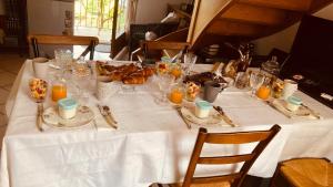 una mesa con un mantel blanco y comida en ella en LA MAISON D'IVONA, en La Tour-de-Salvagny