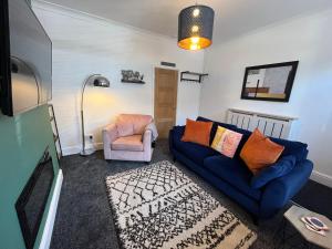 a living room with a blue couch and a chair at Hilton House in Barnsley