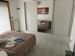 una camera con letto, specchio e divano di La casa di Giada a Peschiera Borromeo