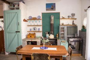 a kitchen with a wooden table and a green door at Furrows Lodge in Nieu-Bethesda