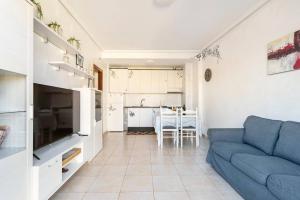 a living room with a blue couch and a kitchen at Casa Ivonne - San Isidro in San Isidro