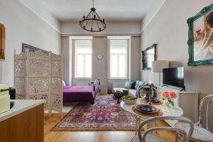 uma sala de estar com uma mesa e um sofá roxo em Bohemian studio in the city centre em Budapeste