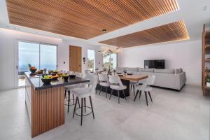 a kitchen and living room with a table and chairs at Elit Villa Psarou in Psarou