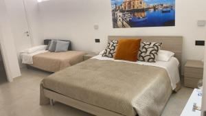 sypialnia z 2 łóżkami i obrazem na ścianie w obiekcie Al Guiscardo 8 w mieście Bari