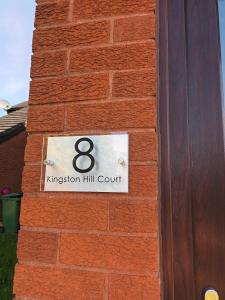 Eine Ziegelmauer mit einem Schild, das Königreich Hill Court liest in der Unterkunft First Floor One bedroom Apartment Quiet Location in Stafford in Stafford