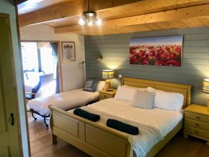 a bedroom with two beds and a painting on the wall at Mulberry Cottage Farm in Wyboston