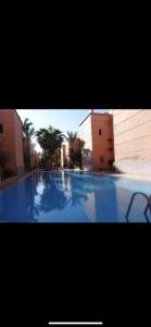 een groot blauw zwembad in een gebouw bij Riad Résidence Al Qaria Assiyahia Riad 22 in Marrakesh