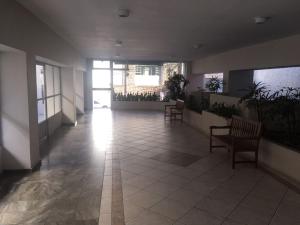 a hallway with chairs and plants in a building at Apto climatizado -garagem in Florianópolis