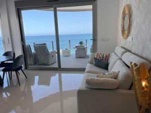 - un salon avec un canapé et une vue sur l'océan dans l'établissement Exclusive apartment for 6 people on the beach - front line - 1st line, à Torrevieja