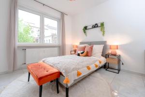 ein Schlafzimmer mit einem großen Bett mit orangefarbenem Sitz in der Unterkunft Travelers Dream Heart of Mannheim in Mannheim