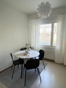 a dining room with a white table and chairs at Annalan Helmi - Viihtyisä koti hyvillä kulkuyhteyksillä ja saunalla in Tampere