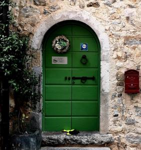 una puerta verde en un edificio de piedra con una zona en B&B Piccolo Tibet, en Lavenone