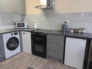 a kitchen with a washing machine and a washer at First Floor One bedroom Apartment Quiet Location in Stafford in Stafford