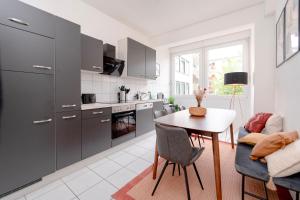 a kitchen with grey cabinets and a table and chairs at Travelers Dream Heart of Mannheim in Mannheim
