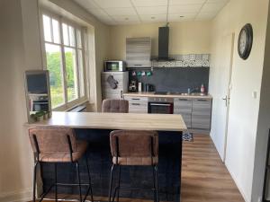 a kitchen with a counter and two bar stools at Situé à 5 minutes de la gare in Besançon