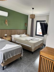 a hotel room with two beds and a flat screen tv at RÜYA BOHEME HOTEL BODRUM in Bodrum City +29 photos