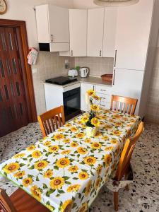 a kitchen with a table with sunflowers on it at Vacanze da Susy sul lago Trasimeno in Passignano sul Trasimeno