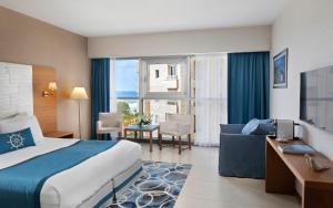 a hotel room with a bed and a living room at Medi Terre Boutique Hotel - By Saida Hotels in Netanya