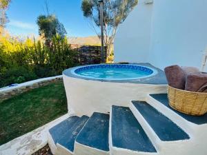a hot tub in a backyard with a wicker basket at 360on62 Farm Cottages in Montagu