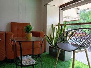 a living room with a couch and a table and a chair at Hotel New Centro in Gulbarga