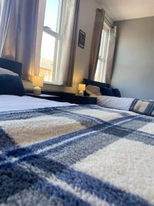 a bedroom with two beds and two windows at Willow House in Birmingham