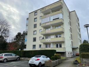 two cars parked in a parking lot in front of a building at Behagliches Apartment für 2 in Wetzlar