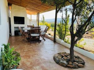 a patio with a table and a tree on it at 360on62 Farm Cottages in Montagu