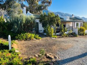 a white house with a gravel driveway at 360on62 Farm Cottages in Montagu