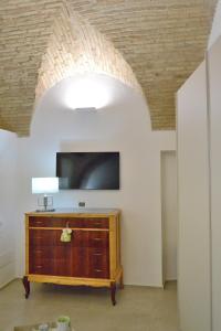 フェッランディーナにあるLorleo Suite Casa Vacanzeのリビングルーム(テレビ、木製ドレッサー付)