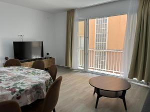 a room with a table and chairs and a television at Gran apartamento diseño in Alicante
