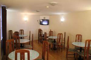 a restaurant with tables and chairs and a tv on the wall at Hotel Royal Mansart in Paris